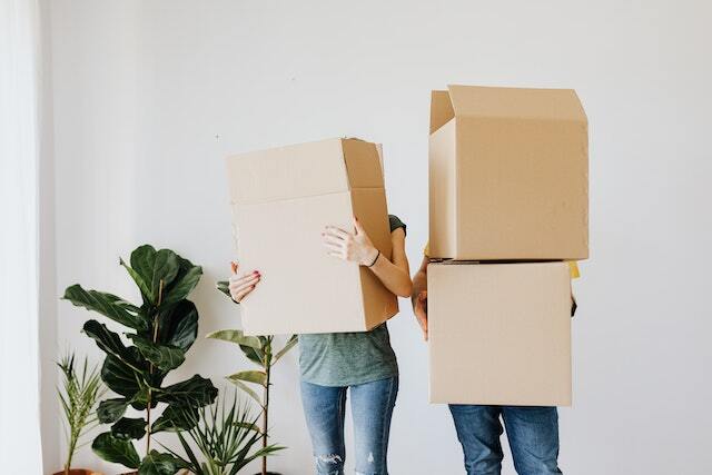 Two people holding cardboard boxes in front of their faces